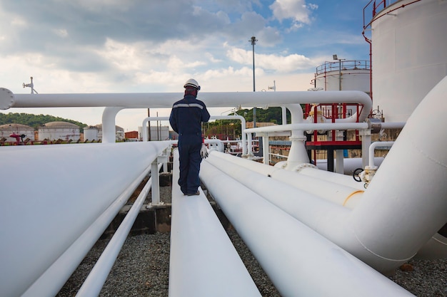 Inspección de trabajador masculino en tubos largos de acero y codo de tubería en la fábrica de aceite de la estación durante la válvula de refinería de la industria de petróleo y gas de tubería de registro de verificación visual.