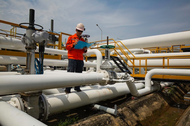 Inspección del trabajador masculino en la válvula del registro de control visual de la tubería de petróleo y gas