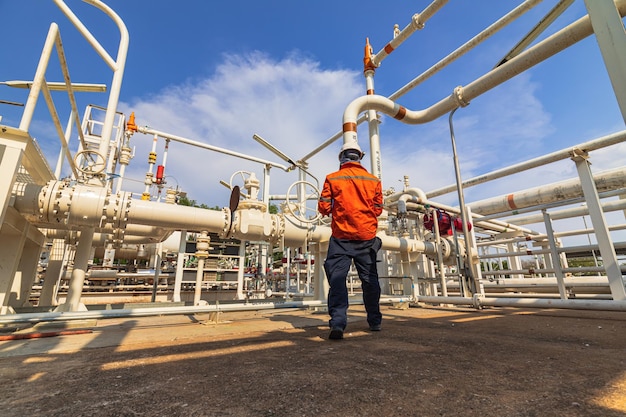 Inspección del trabajador masculino en la válvula del registro de control visual de la tubería de petróleo y gas