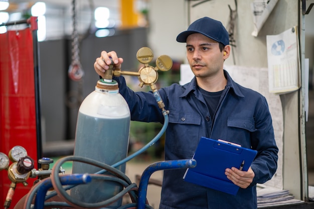 Inspector comprobando un tanque de gas en una fábrica industrial