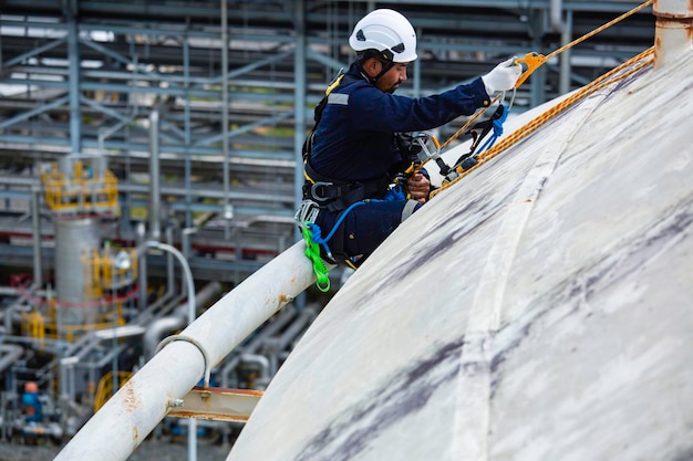 Inspektion von männlichen Sitdown-Arbeitern mit Sicherheitsleine, die an einem hohen Seil arbeitet