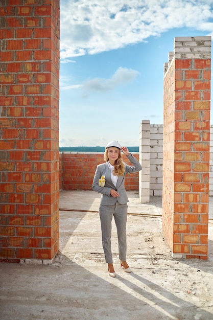 Inspetor de belo edifício com desenhos técnicos olhando para o futuro