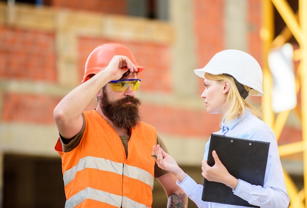 Foto inspetor e construtor brutal barbudo discutem o progresso da construção inspeção do projeto de construção correções e multas da inspeção de construção conceito do inspetor de segurança discutir o projeto de progresso