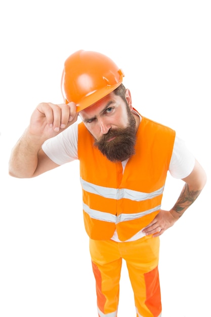 Inspetor exigente. A segurança é o ponto principal. Capacete de proteção de homem e uniforme. Câmera olhando confiante do construtor do trabalhador. Conceito de equipamento de proteção. O construtor cruzou as mãos no peito. Construtor forte e bonito.