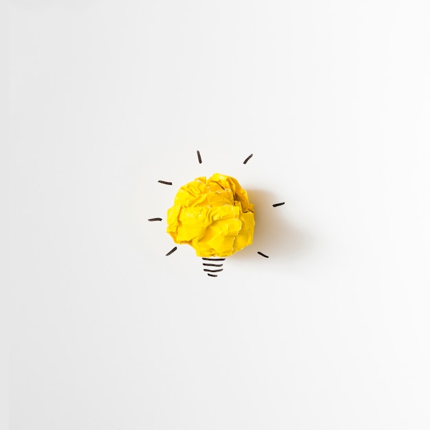 Foto inspiración arrugado idea de bombilla de papel amarillo sobre fondo blanco