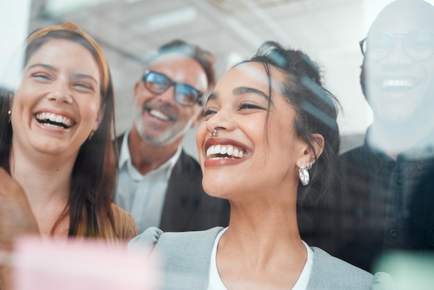 Inspirado com as melhores ideias Foto de um grupo de empresários fazendo brainstorming com notas em uma parede de vidro em um escritório