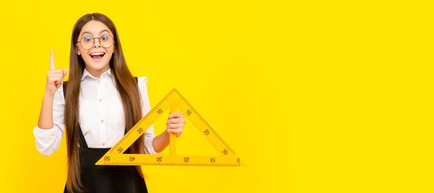 Inspirado con la idea de la niña adolescente sostenga el triángulo de regreso a la escuela álgebra y geometría Retrato de colegiala estudiante estudio banner encabezado Escuela niño cara copyspace