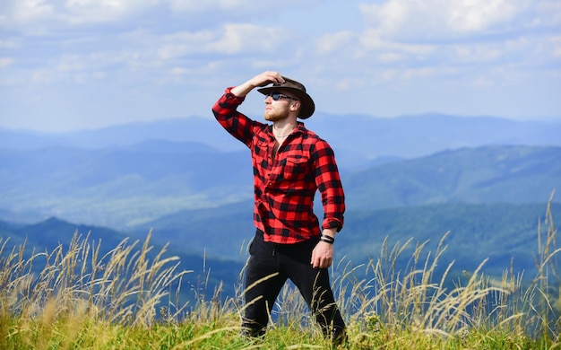 Inspirationssuche. Mann auf Berglandschaft. campen und wandern. Landschaftskonzept. Bauer auf Rancho. Reiseabenteuer. Hipster sexy Macho-Mann im karierten Hemd. Cowboy mit Hut im Freien.