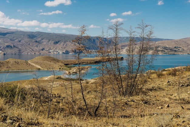 Inspirierende Natur, blaues Wasser, Pisten und Berge in der Sonne