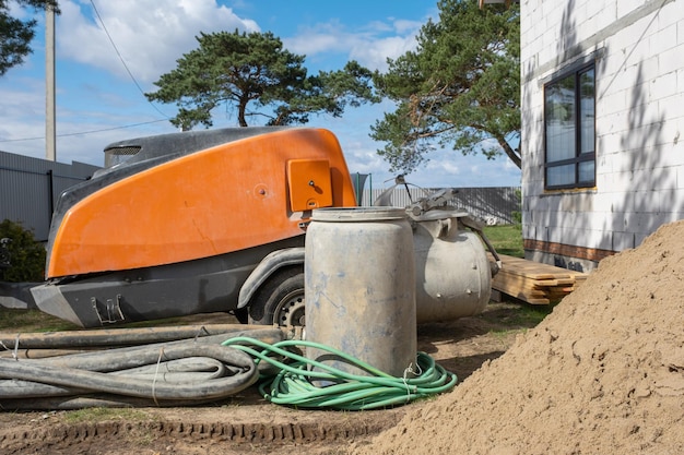 Instalação de máquina com misturador para alimentação de mistura de cimento para despejar betonilha semi-seca em casa Canteiro de obras com lâmina de preparação de areia para nivelar o piso áspero da casa de campo