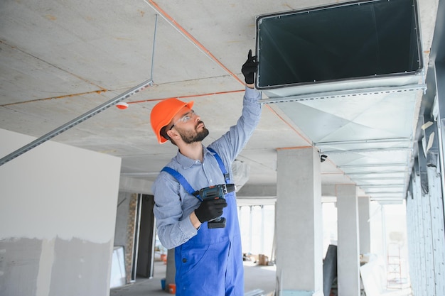 Instalação de sistema de aquecimento e resfriamento de armazém de tema industrial por técnico caucasiano profissional Ventilação de edifícios comerciais Canais retangulares Distribuição de ar