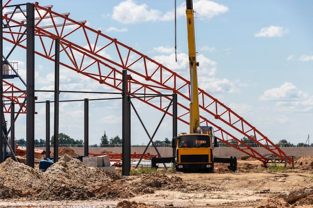 Instalação de treliças e armação de metal durante a construção de um prédio ou fábrica industrial O trabalho dos instaladores durante a instalação do telhado Construção de uma grande oficina de armação