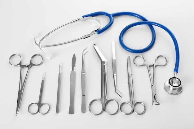 Instalação plana de instrumentos cirúrgicos em fundo branco