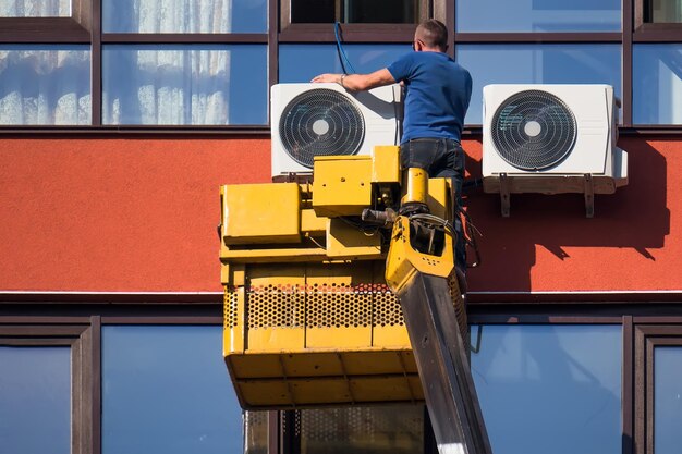 Instalación de aire acondicionado exterior en un edificio alto en la grúa
