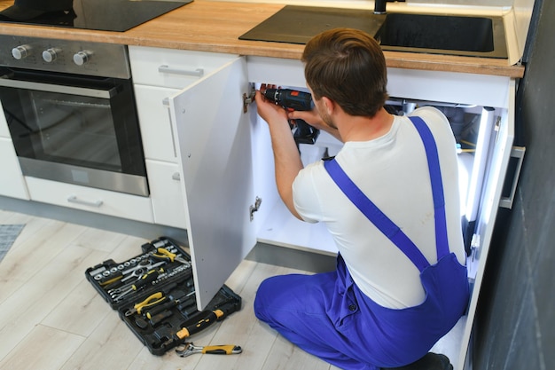 Foto instalación de cocina trabajador montando muebles.