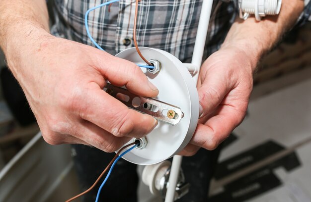 Foto instalación de lámpara. aislante eléctrico para bombilla. restauración en interior.