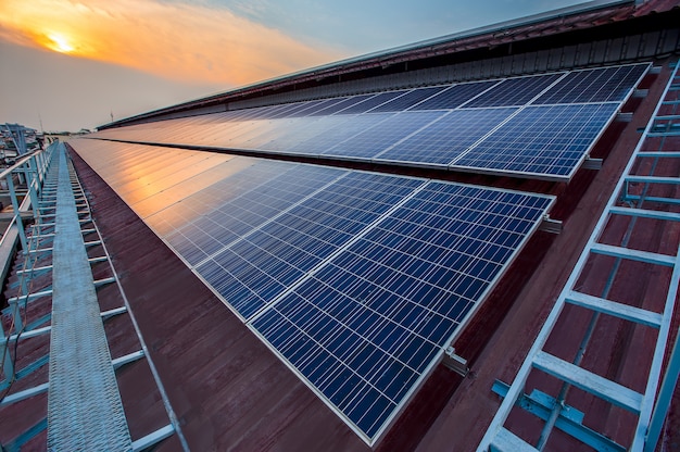 Instalación de paneles solares fotovoltaicos en un techo de fábrica, fuente de electricidad alternativa - Concepto de recursos sostenibles.