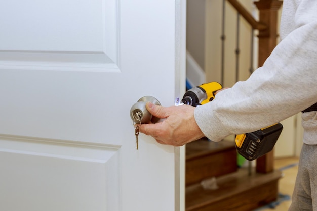 Instalando a trava da porta e as mãos de hardware reparando uma fechadura da porta com uma chave de fenda