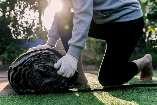 Instale césped artificial para el jardín de su casa. Disposición de un rollo de césped falso y decoración para un jardín verde de bricolaje.