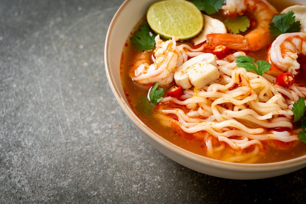 Instant-Nudeln Ramen in scharfer Suppe mit Garnelen (Tom Yum Kung) - asiatische Küche