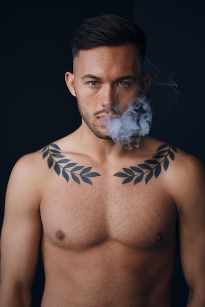 Instantâneos de modelagem Pensativo sério bronzeado atraente homem nu bonito pensando olha para a câmera para você fumando posando isolado no fundo preto do estúdio Oferta de moda Copiar espaço para anúncio Closeup