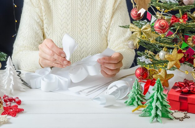 Instrucciones fotográficas paso a paso para hacer una decoración de papel de Navidad paso 3 conecta los elementos en forma de lágrima en una tira