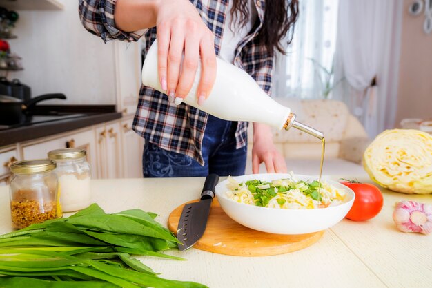 Instrucciones paso a paso sobre cómo cocinar una ensalada de verduras con repollo, tomates, cebollas verdes, especias y aceite de oliva. Paso 5. Llena la ensalada con aceite de oliva al gusto.