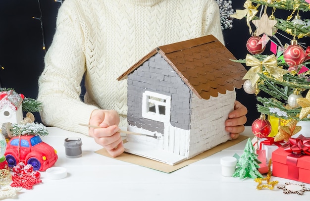 Instruções de fotos passo a passo para fazer uma decoração de Natal uma casa de papelão passo 4 pintando as paredes com tinta cinza