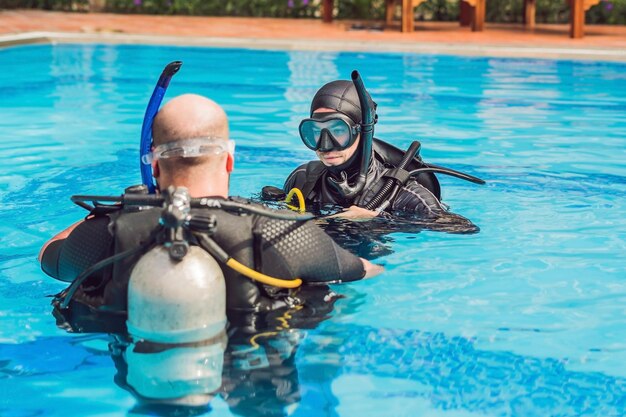 Foto instructor de buceo y alumnos. el instructor enseña a los estudiantes a bucear.