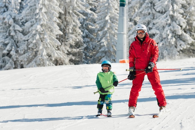 Instructor de esquí aprendiendo a esquiar a niño