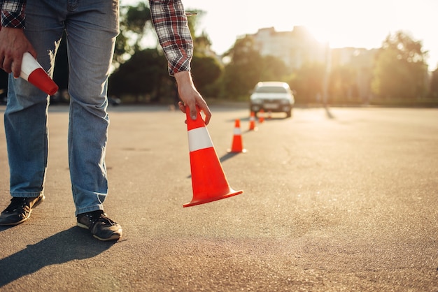 Instructor establece el cono, concepto de escuela de conducción