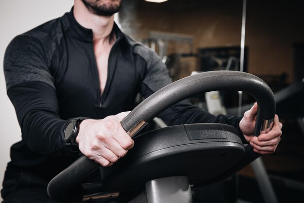 Instructor de fitness en una bicicleta estática en un gimnasio de cerca