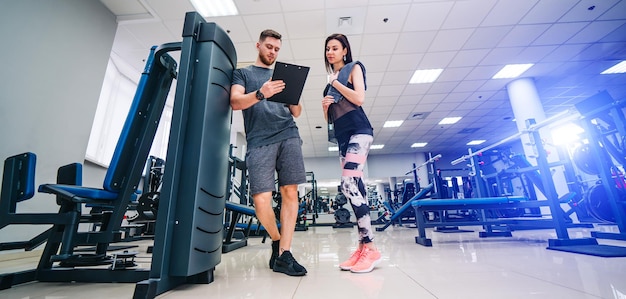 El instructor de fitness ejercita al cliente en el gimnasio programa personal enfoque selectivo concepto de vida saludable