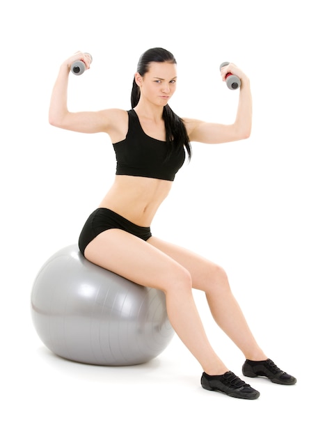 Instructor de fitness encantador con pesas en pelota de pilates