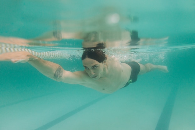 Instructor de natación masculino bajo el agua