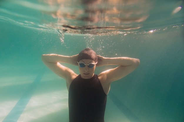 Instructor de natación nadando bajo el agua