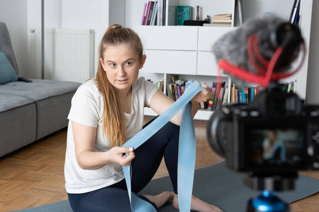 Foto instructor de pilates grabando curso en línea o tutorial para redes sociales en una cámara de video