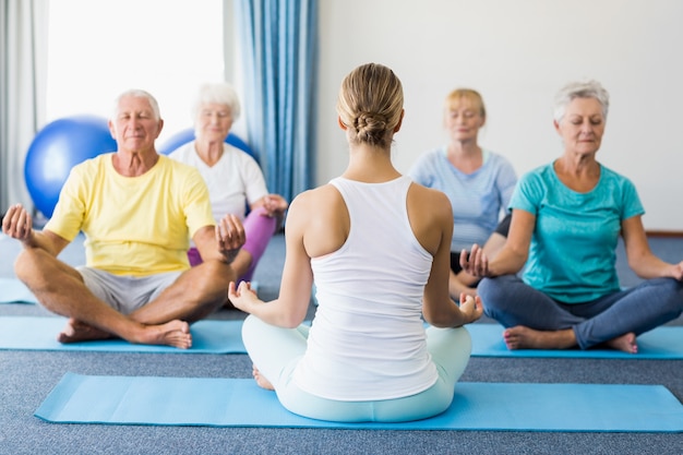 Instructor realizando yoga con personas mayores