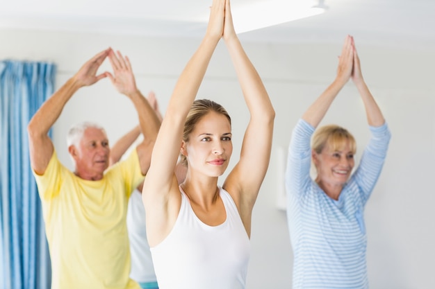 Instructor realizando yoga con personas mayores
