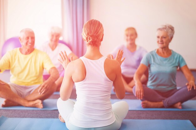 Instructor realizando yoga con personas mayores