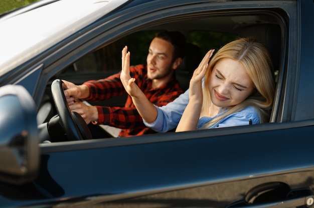 Instructor de señora y hombre en coche, situación de accidente, escuela de conducción. hombre enseñando a una mujer a conducir un vehículo. educación sobre licencias de conducir