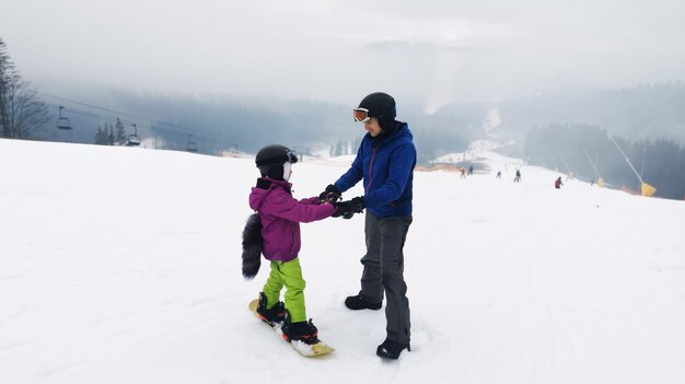 Instructor de snowboard con niño