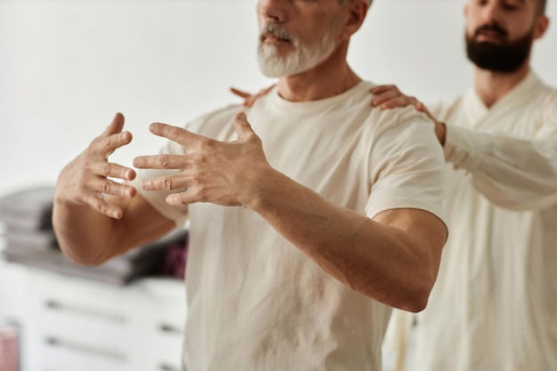 Foto instruktor passt die position des älteren qigong-schülers an