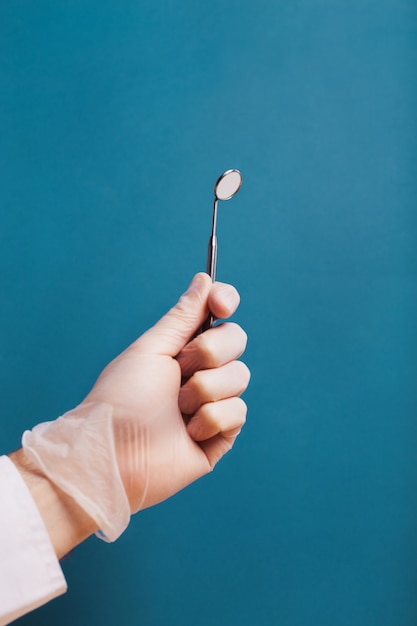 Instrumento dental en una mano en un guante médico