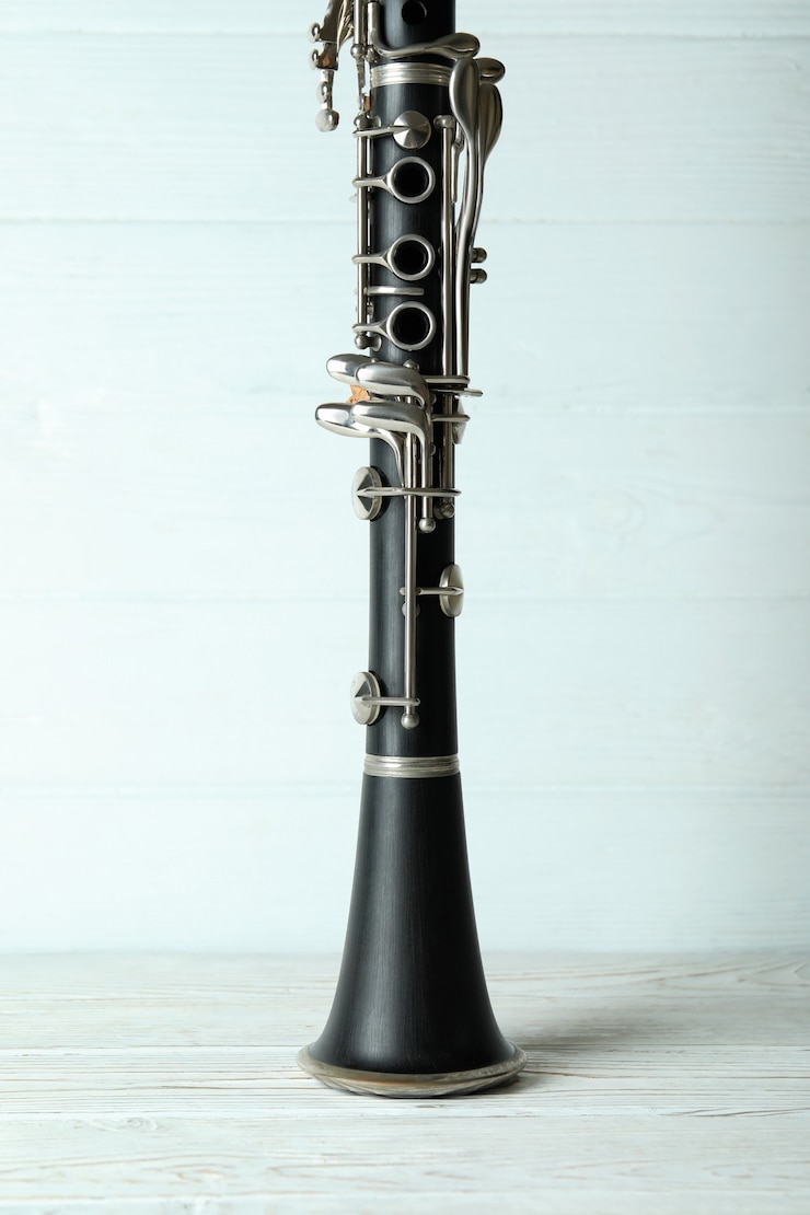 Foto instrumento musical de clarinete em fundo branco de madeira.