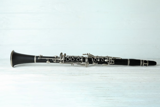 Instrumento musical de clarinete em fundo branco de madeira.