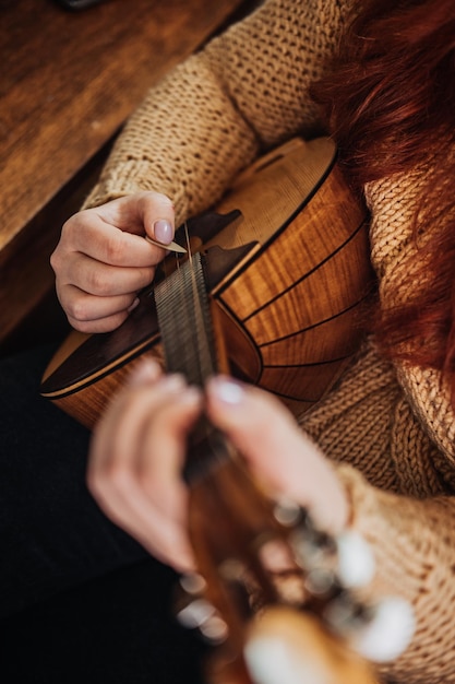 Instrumento musical folclórico Domra en mano de mujer manos femeninas con cuerdas musicales hechos a mano de madera natural