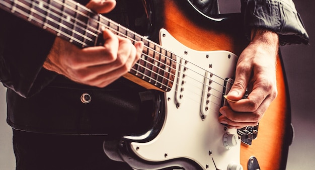 Instrumento musical Guitarra elétrica Repetição de banda de rock Festival de música Homem tocando violão Feche a mão tocando violão Músico tocando violão música ao vivo