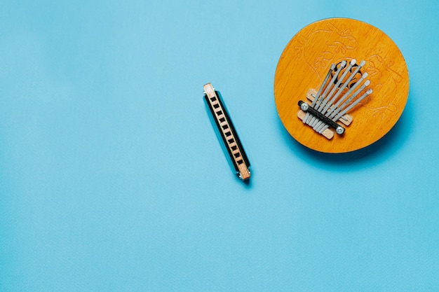 Instrumento musical kalimba y armónica sobre un fondo azul.