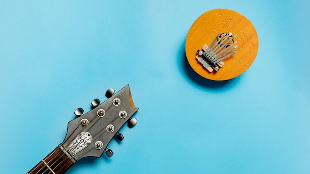 Instrumento musical kalimba e guitarra em fundo azul